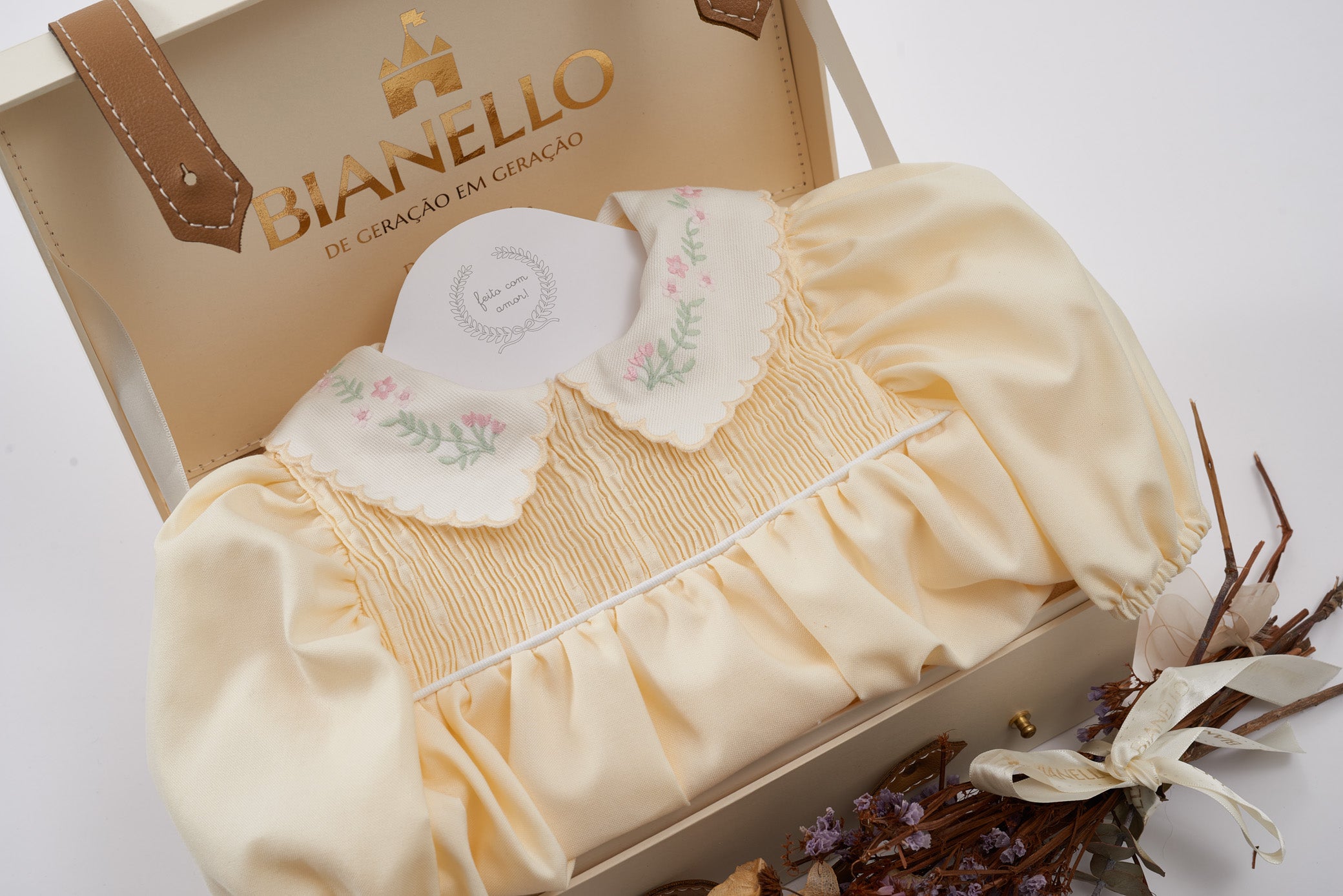 Bombacho Alice amarelo com bordado floral na gola e mangas bufantes, feito em percal 100% algodão, ideal para bebês de 3 a 18 meses.