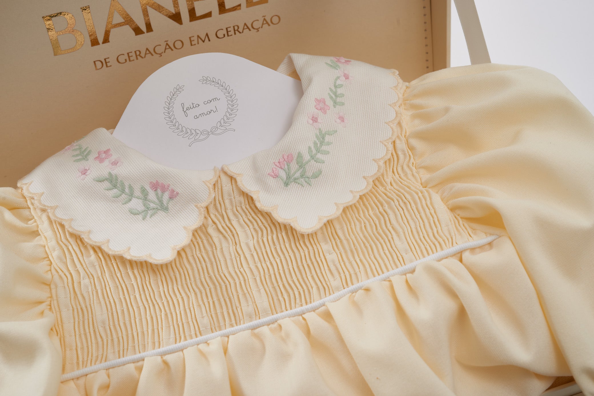 Bombacho Alice amarelo com bordado floral na gola e mangas bufantes, feito em percal 100% algodão, ideal para bebês de 3 a 18 meses.