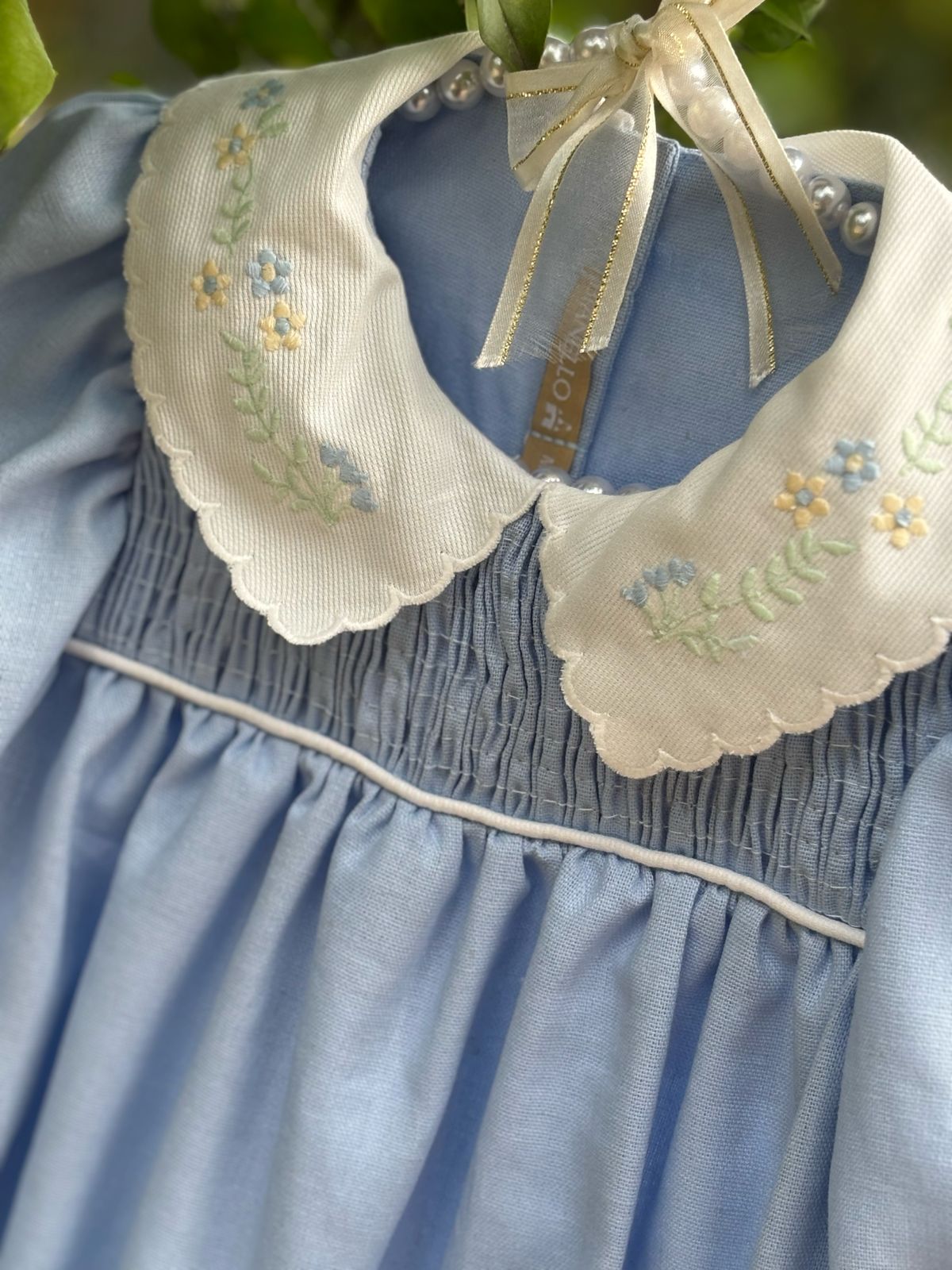 Bombacho Alice amarelo com bordado floral na gola e mangas bufantes, feito em percal 100% algodão, ideal para bebês de 3 a 18 meses.