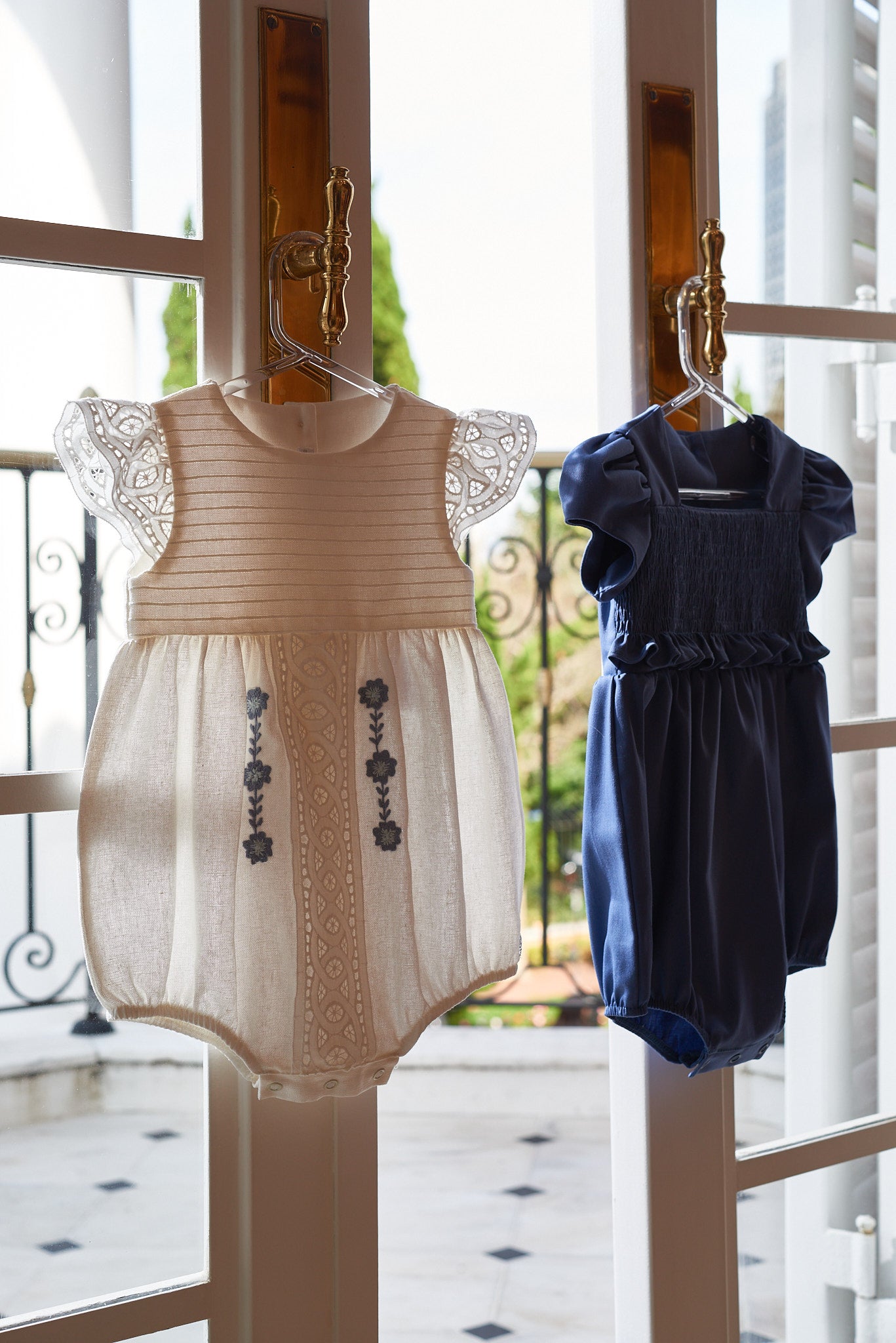 Bombacho Mirela em linho com bordado azul, babados delicados e botões nas costas e entrepernas. Elegância e conforto para bebês de 3 a 18 meses.

