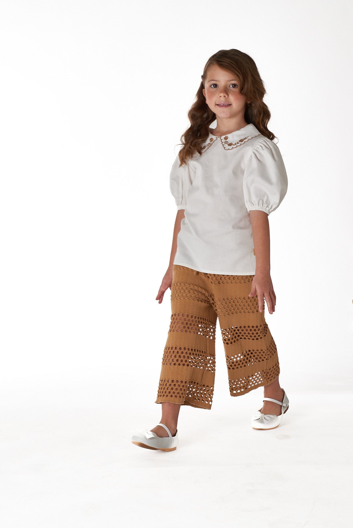 Calça infantil Luna com desenho vazado e efeito rendado, ideal para meninas de 2 a 8 anos.

