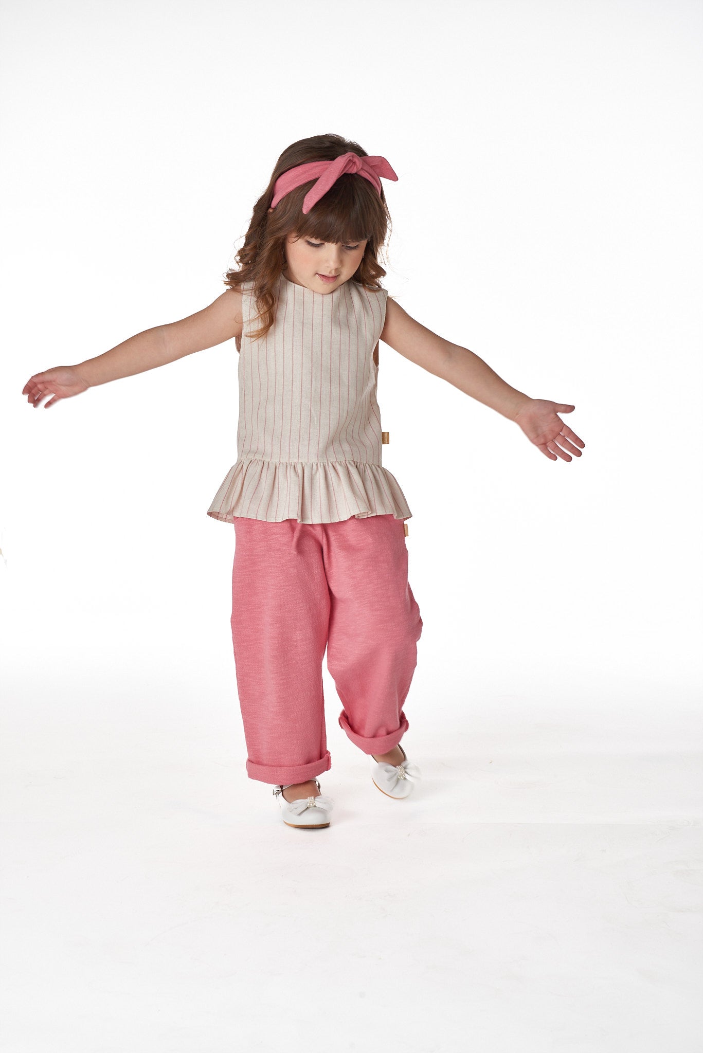 Calça Mathy infantil com bolsos laterais, caimento soltinho e cintura elástica, em malha goiaba ou linho bege.


