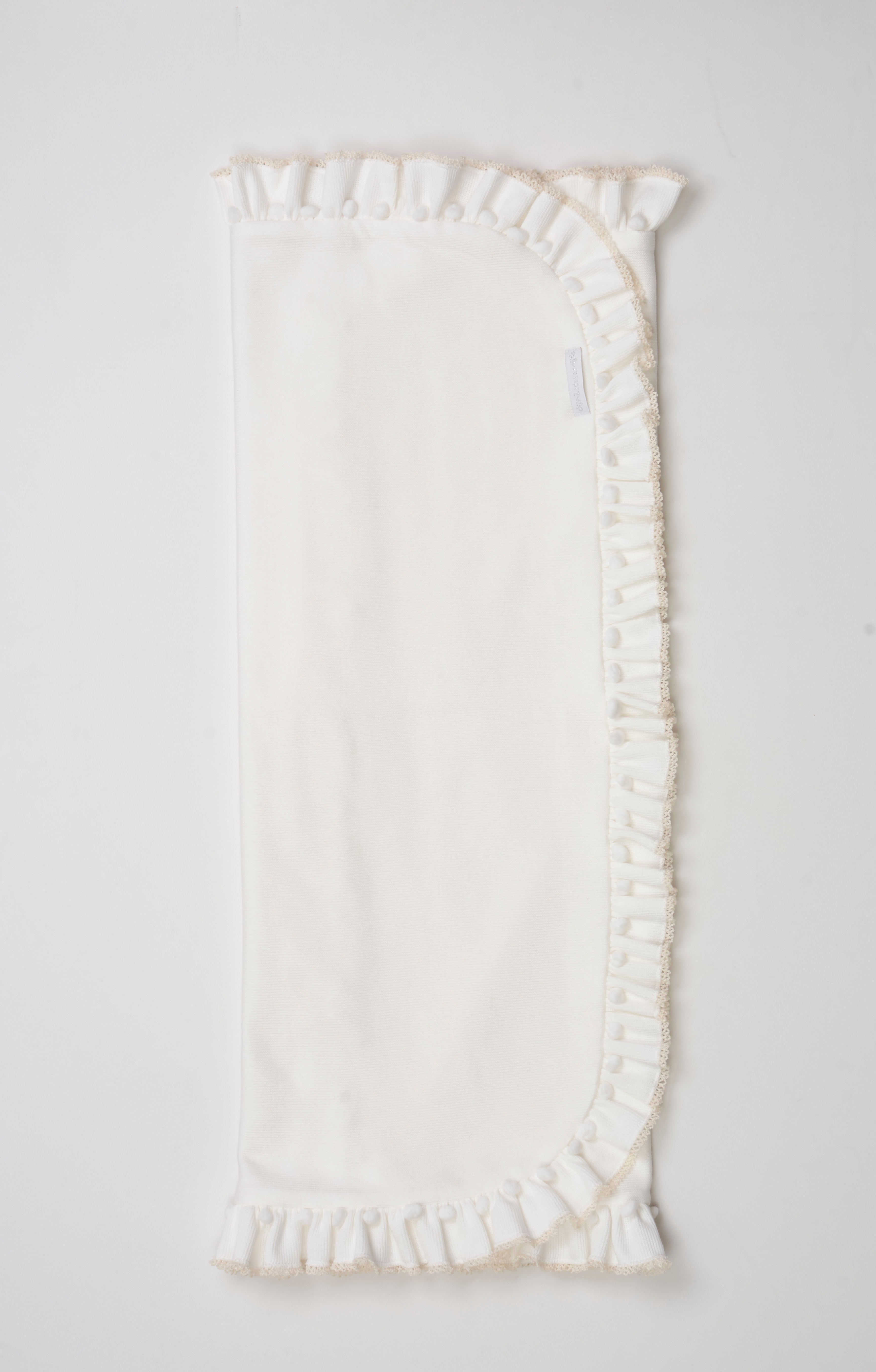 Manta tricotada com babado, mini pompom e picueta – aconchegante e delicada para o bebê.

