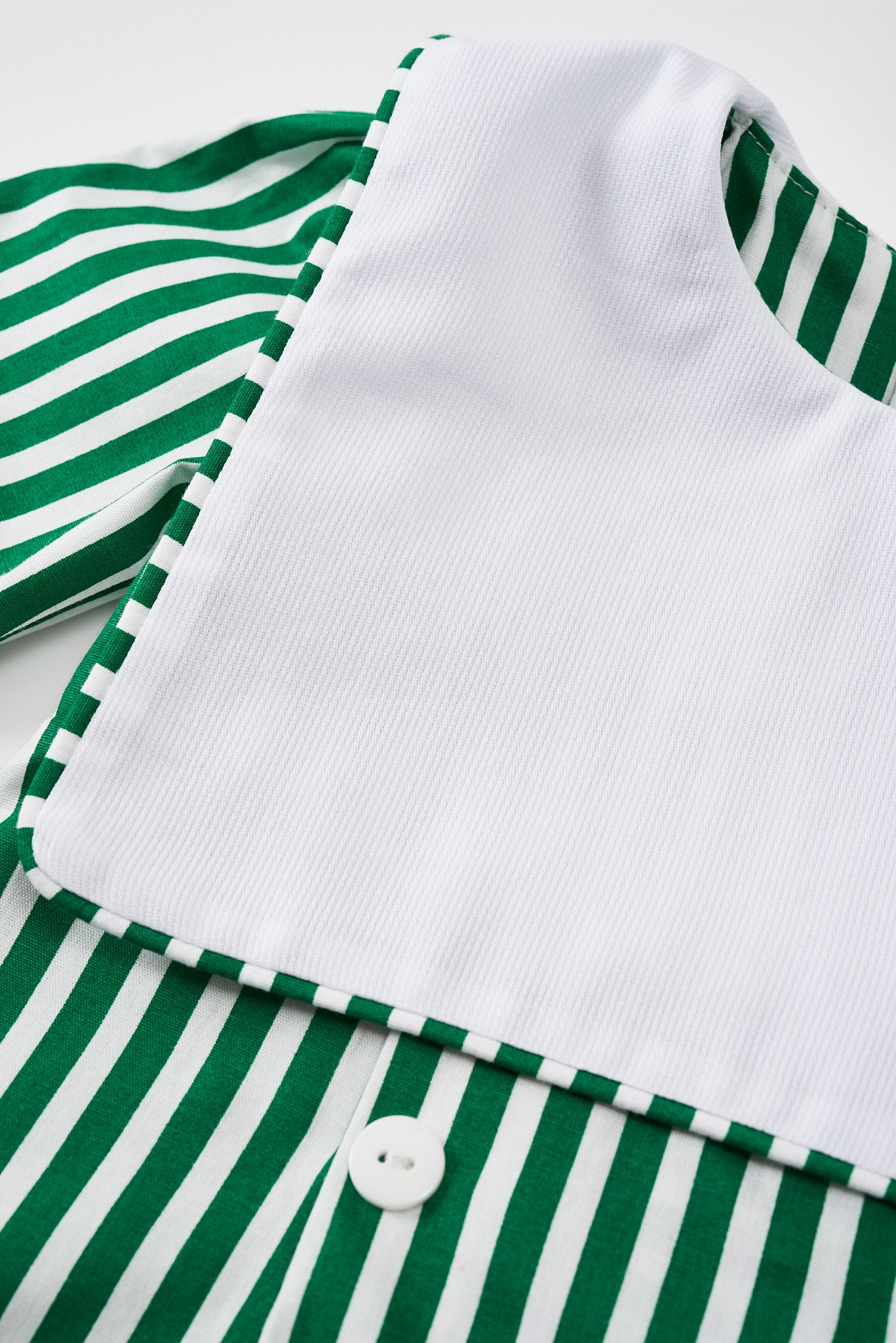 Romper em tricoline com pregas, bordado e botões. Confortável, elegante e fácil de vestir. Para bebês de 3 a 18 meses.

